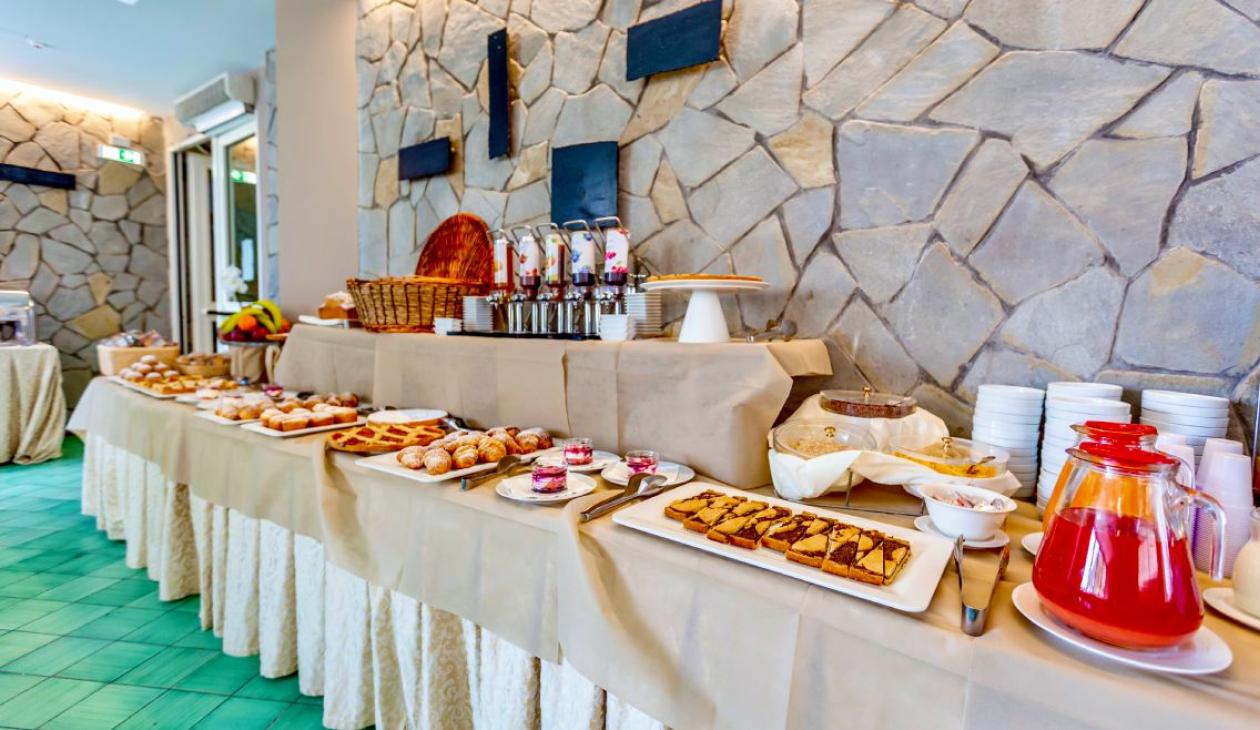 Buffet ricco di dolci e bevande, atmosfera accogliente e invitante.